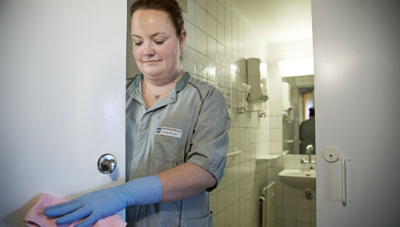 Serviceassistent Camilla Svendsen gør dørgreb til toilet rent på ældrecentret Rønnebækhus i Vallensbæk Kommune.